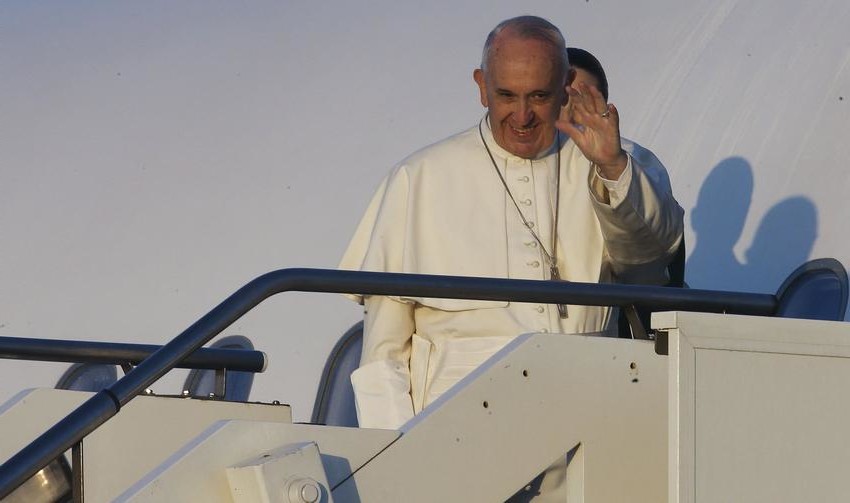 Pope Francis waves as he boards a plane at Fiumicino Airport in Rome