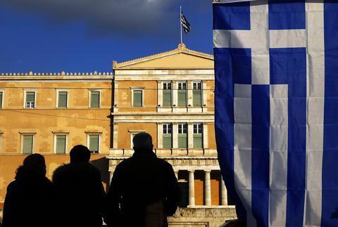 People are silhouetted in front of the parliament during an anti-austerity and pro-government demonstration in Athens