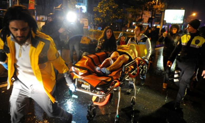 An injured woman is carried to an ambulance from a nightclub where a gun attack took place during a New Year party in Istanbul
