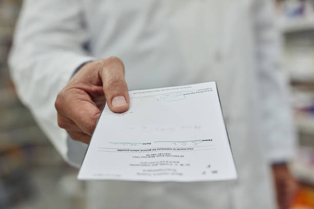 Cropped shot of a pharmacist holding a prescription form