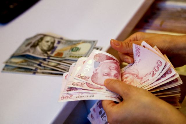 FILE PHOTO: FILE PHOTO: A money changer counts Turkish lira banknotes at a currency exchange office in Ankara