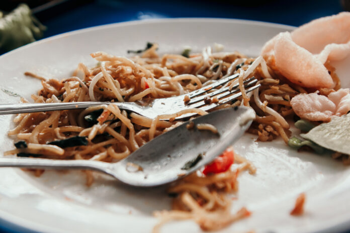 A,White,Plate,Filled,With,Leftover,Fried,Noodles,,Typical,Of