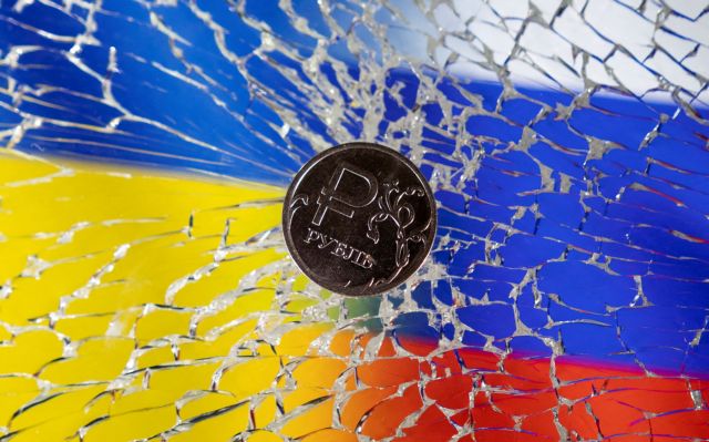FILE PHOTO: Illustration shows Russian Rouble coin is seen on a broken glass and displayed Ukrainian's and Russian's flags